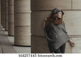 Carefree Caucasian woman leaning on pillar