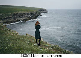 Caucasian woman photographing ocean
