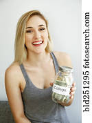 Caucasian woman showing jar of money for college Caucasian woman showing jar of money for college