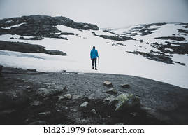 Distant Caucasian man hiking in winter