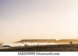 Distant people walking on beach