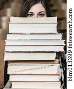 Mixed race student holding stack of books Mixed race student holding stack of books