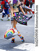 Person wearing high heel boots carrying purse in pride parade