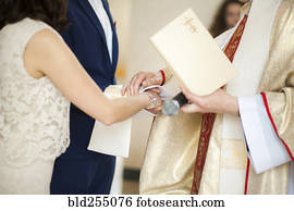 Priest and couple joining hands in wedding