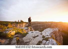 Caucasian man standing on remote cliff
