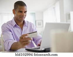 Mixed race man shopping online with credit card