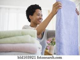 African American woman folding towels African American woman folding towels