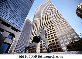Businessman running past highrise building