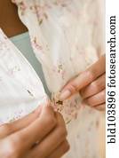 Cape Verdean woman buttoning shirt