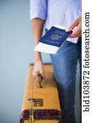 Cape Verdean woman holding passport and suitcase