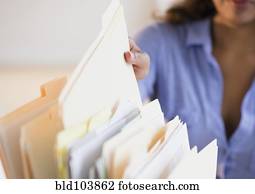 Cape Verdean woman picking up file folder