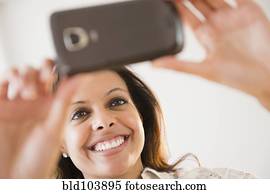 Cape Verdean woman taking photograph with cell phone