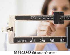 Cape Verdean woman weighing herself