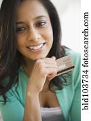 Mixed race woman holding credit card Mixed race woman holding credit card