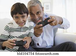 Hispanic grandfather and grandson playing video game