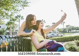 Caucasian mother and daughter taking self-portrait