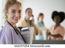 Smiling nurse holding clipboard in hospital