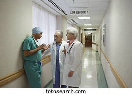 Surgeon talking to two doctors in hospital hallway, Bethesda, Maryland, United States
