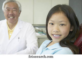 Senior Asian male dentist with young patient