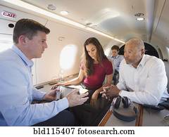 Business people talking on airplane
