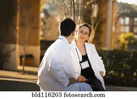 Hispanic doctors talking outdoors