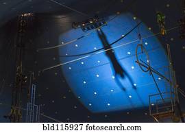 Shadow of acrobat in spotlight on wall