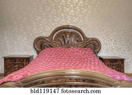 Bed with carved wooden headboard