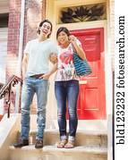 Couple standing on front stoop with house key