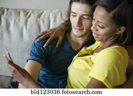 Couple taking self-portrait on sofa