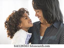 African American mother and daughter hugging and smiling