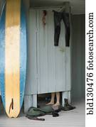 Caucasian surfer changing in beach hut