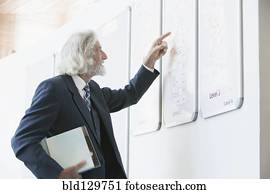 Senior Caucasian businessman reading directory