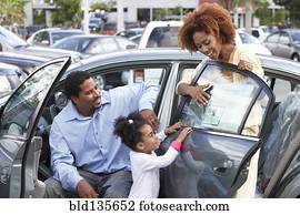 Black family admiring new car