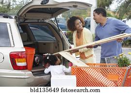 Black family loading car at home improvement store