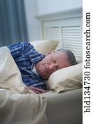 Senior Caucasian man sleeping in bed