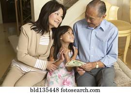 Senior couple giving granddaughter money