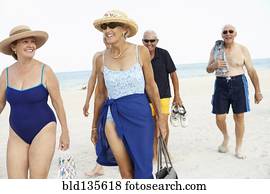 Senior friends walking on beach
