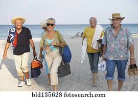 Senior friends walking on beach