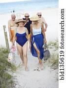 Senior friends walking on beach