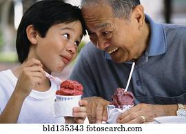 Senior man and grandson eating ice cream outdoors Senior man and grandson eating ice cream outdoors