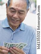 Senior man counting money outdoors Senior man counting money outdoors