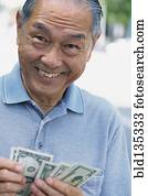 Senior man counting money outdoors Senior man counting money outdoors