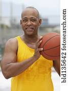 Senior man playing basketball outdoors Senior man playing basketball outdoors