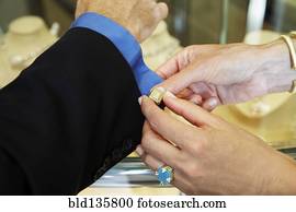 Woman buttoning husband's cuff link
