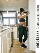 Athletic mixed race woman searching for food in fridge