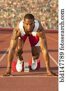 Black runner at starting block in race
