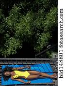 Black woman sunbathing on fire escape