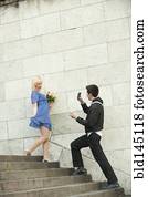 Caucasian man photographing girlfriend