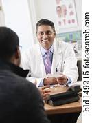 Doctor handing patient prescription in doctor's office