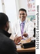 Doctor handing patient prescription in doctor's office